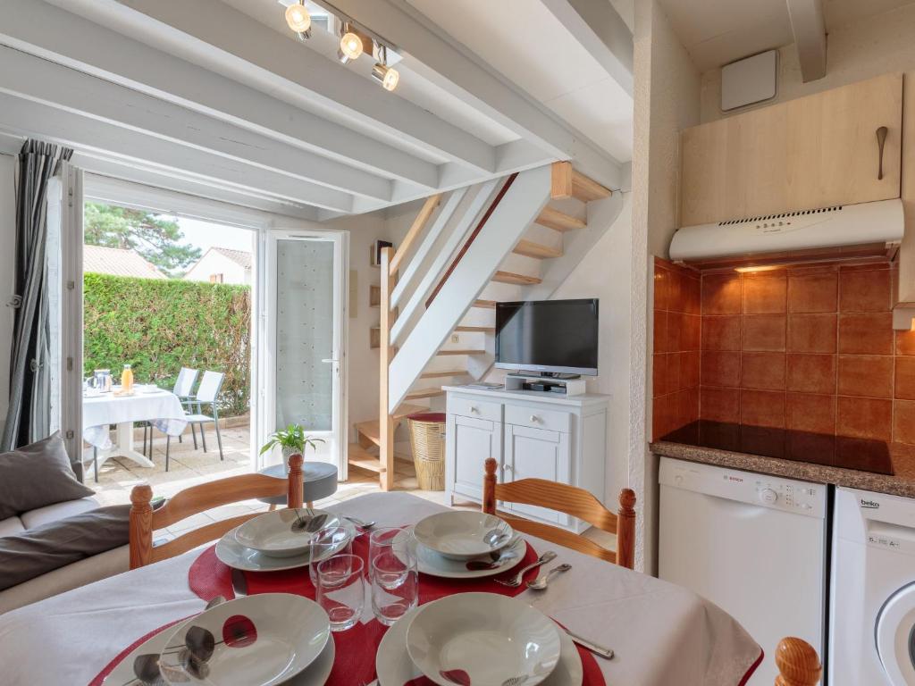 a kitchen and dining room with a table and chairs at Holiday Home Les Jardins de la Palmyre-2 by Interhome in Les Mathes