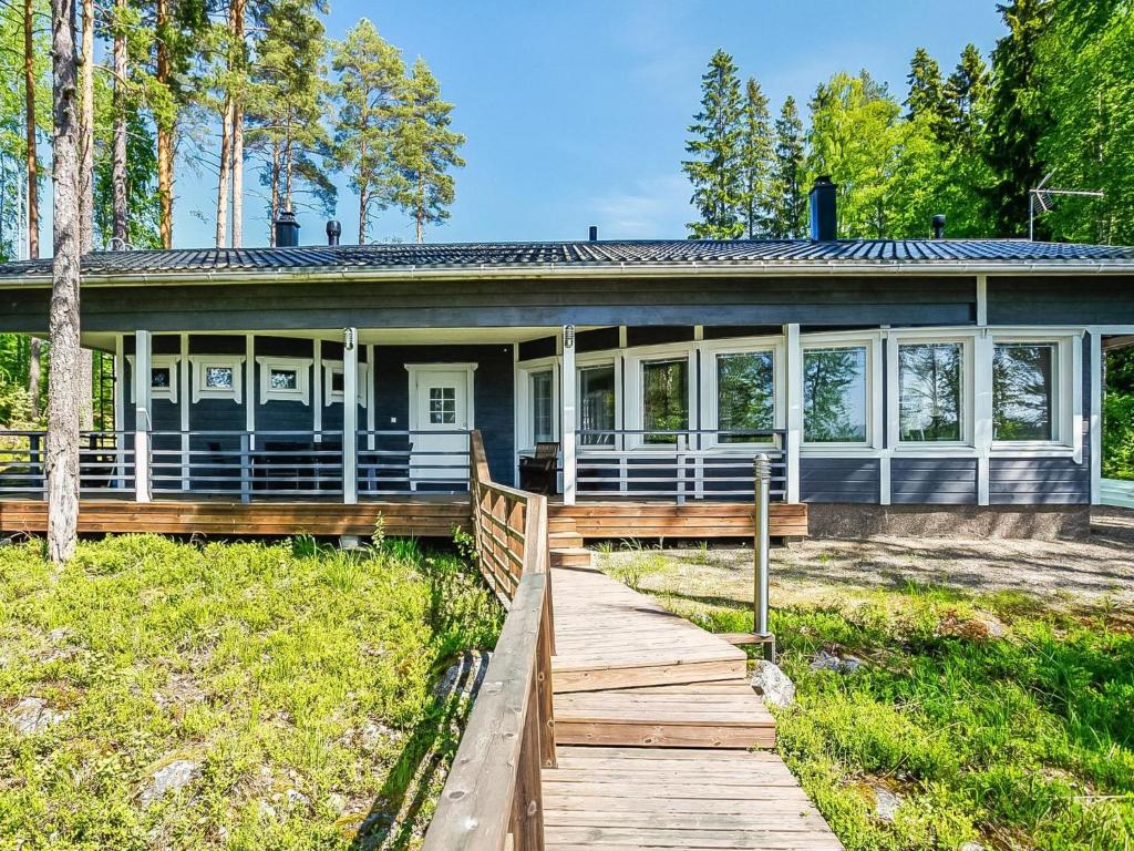 una casa con una pasarela de madera delante de ella en Holiday Home Aurinkokaari by Interhome, en Heinävesi