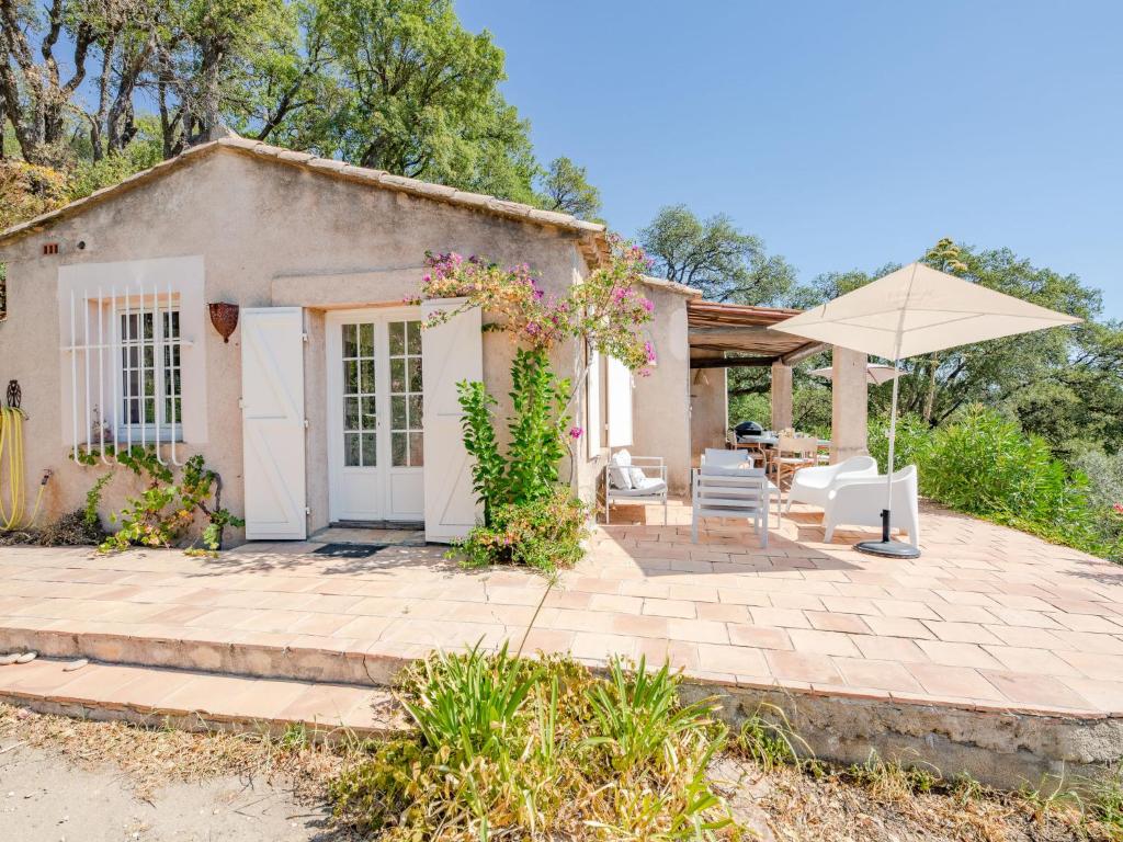 une maison avec une terrasse et un parasol dans l'établissement Holiday Home Le Clos d'Estelle by Interhome, à La Garde-Freinet