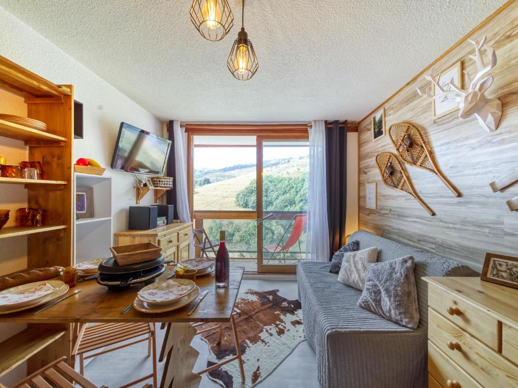 a living room with a couch and a table at Studio Soyouz Vanguard-99 by Interhome in Le Corbier