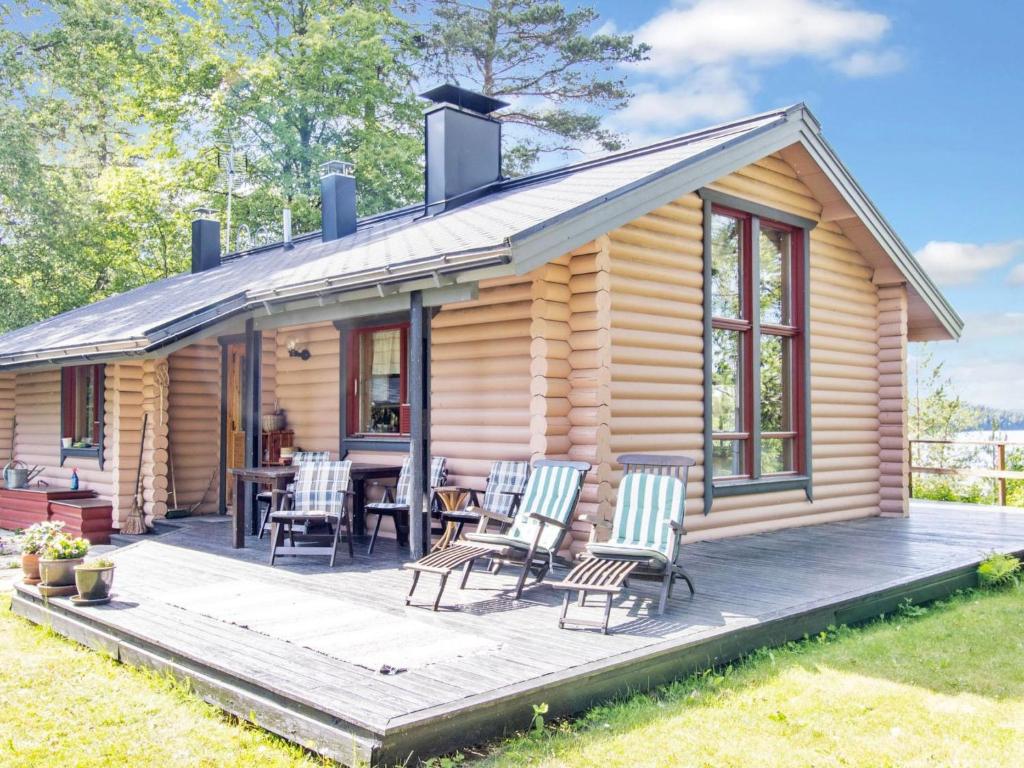 a log cabin with a table and chairs on a deck at Holiday Home Jyrkänne by Interhome in Pyöli