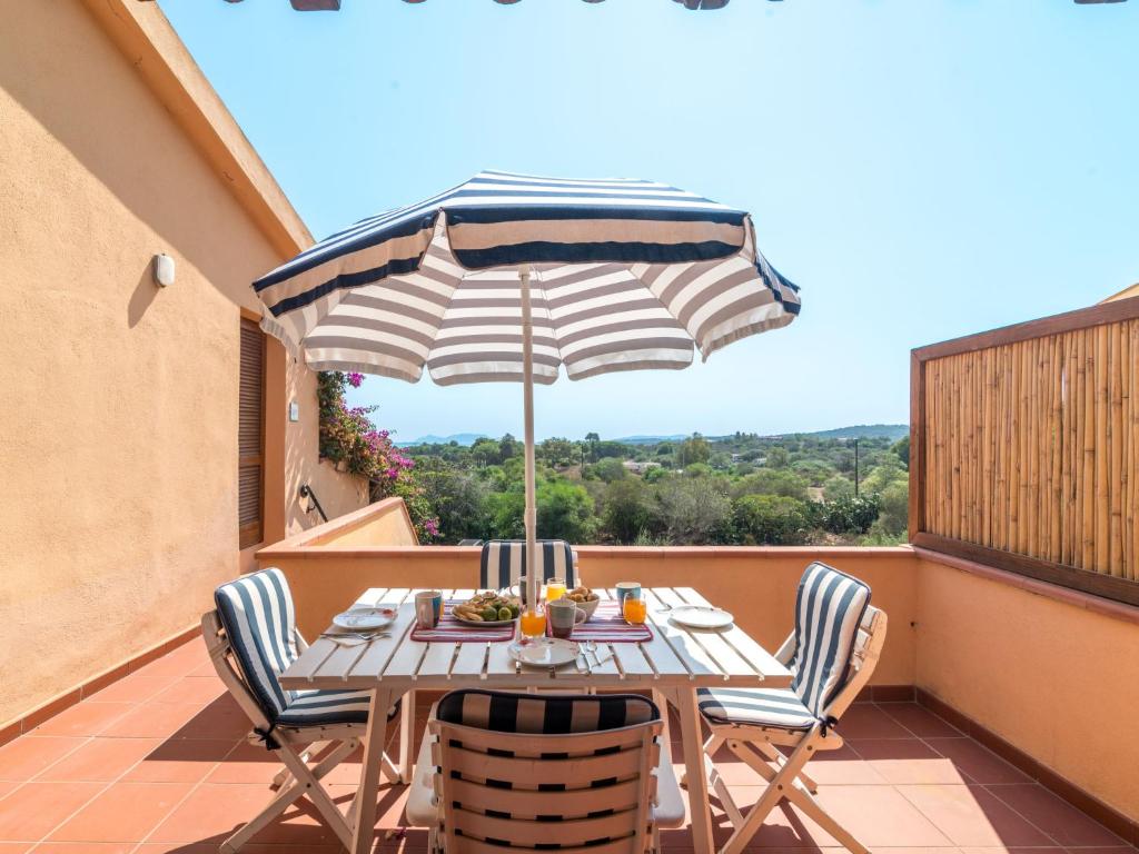 una mesa y sillas en un balcón con sombrilla en Apartment Arcobaleno by Interhome, en Porto Istana