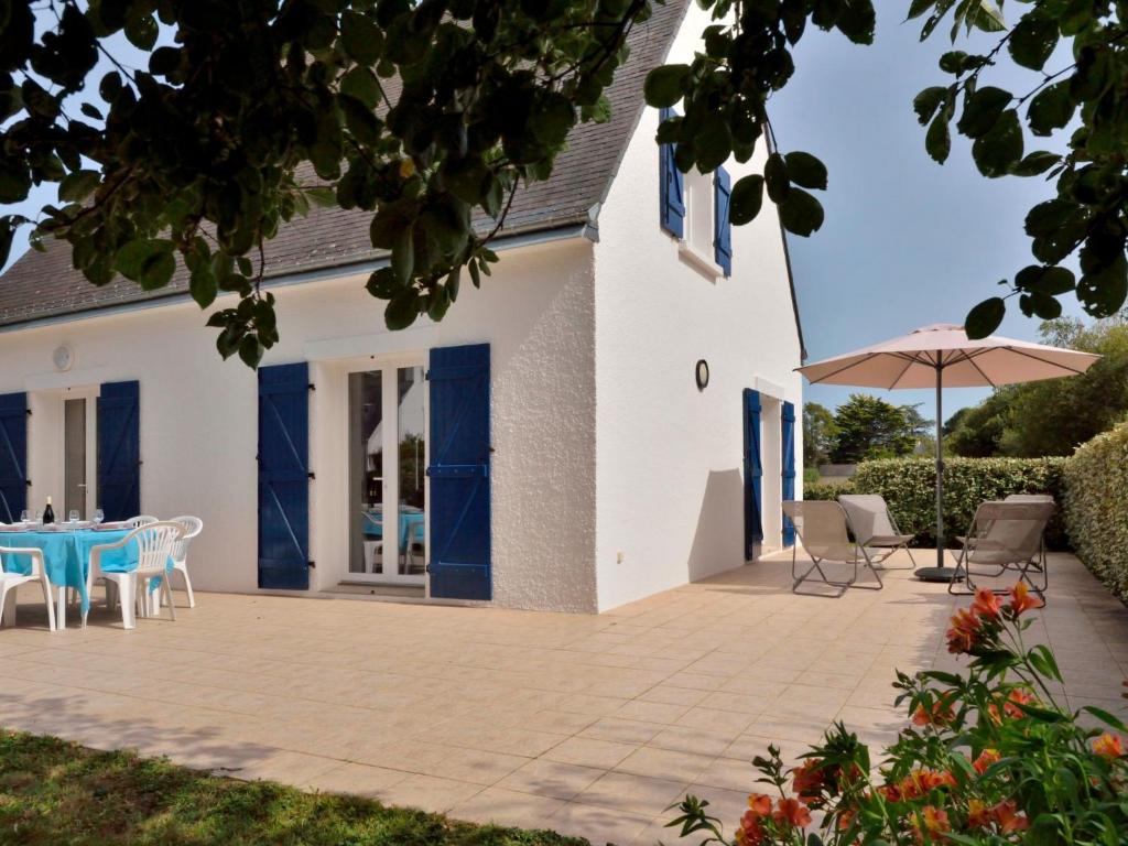 a house with a patio with a table and an umbrella at Holiday Home Les Agapanthes by Interhome in Saint-Gildas-de-Rhuys