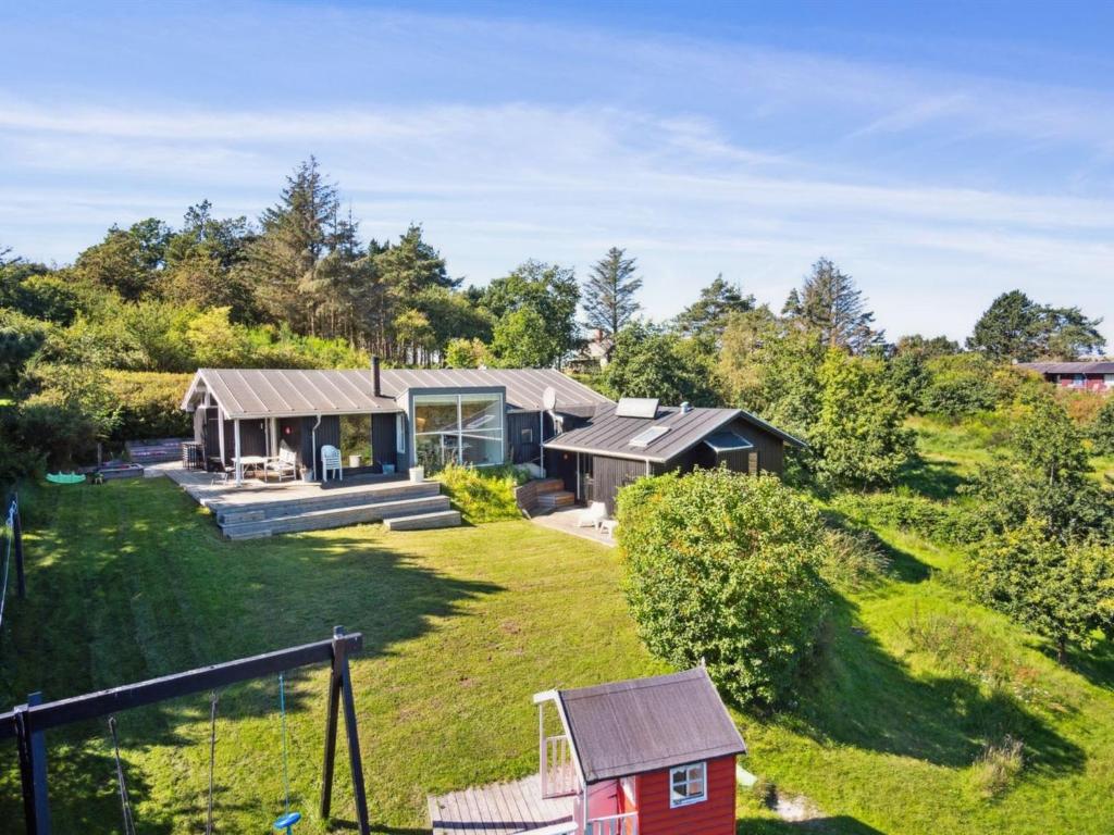 una casa en una colina con una casa roja en Holiday Home Henryk - 350m from the sea in Djursland and Mols by Interhome en Ørby