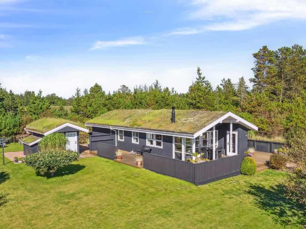 een afbeelding van een huis met een grasdak bij Holiday Home Ofelia - 2-5km from the sea in NW Jutland by Interhome in Blokhus