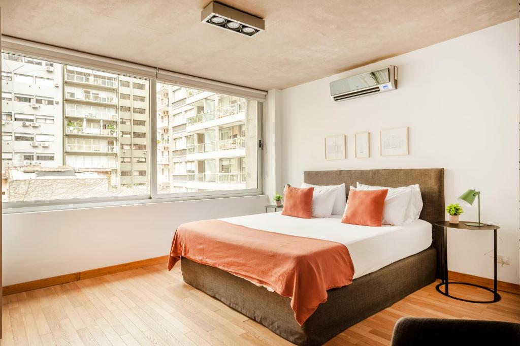 1 dormitorio con cama y ventana grande en Viví Buenos Aires en este Studio de Diseño #202 en Buenos Aires
