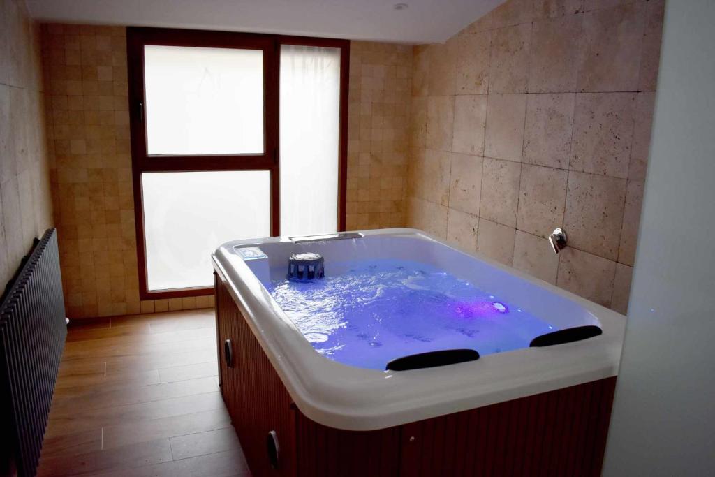 eine große Badewanne in einem Zimmer mit Fenster in der Unterkunft Casa Rural Puente Moneo in Garcibuey