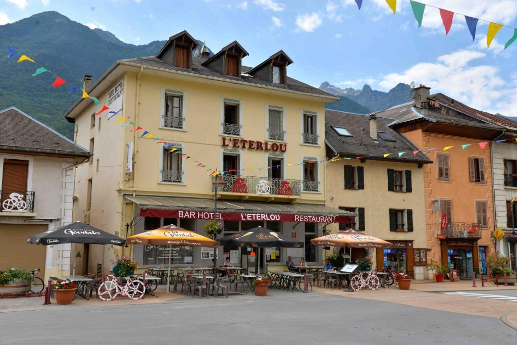 a building with tables and umbrellas in a town at Eterlou in La Chambre