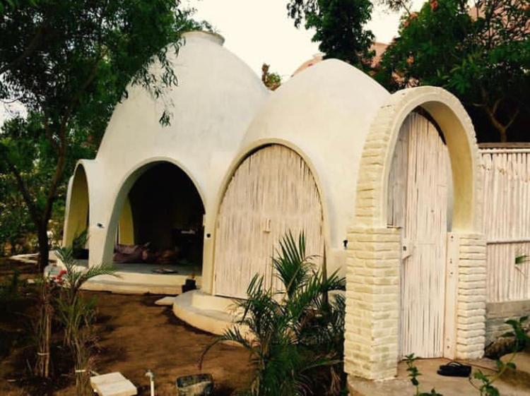 una pequeña casa blanca con dos puertas en un patio en Villa Kingdome - 1 Bedroom, en Teluknarat