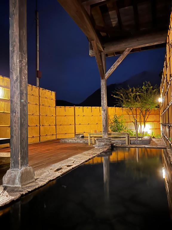 una piscina d'acqua in un patio di notte di 湯布院 旅館 やまなみ Ryokan YAMANAMI a Yufu