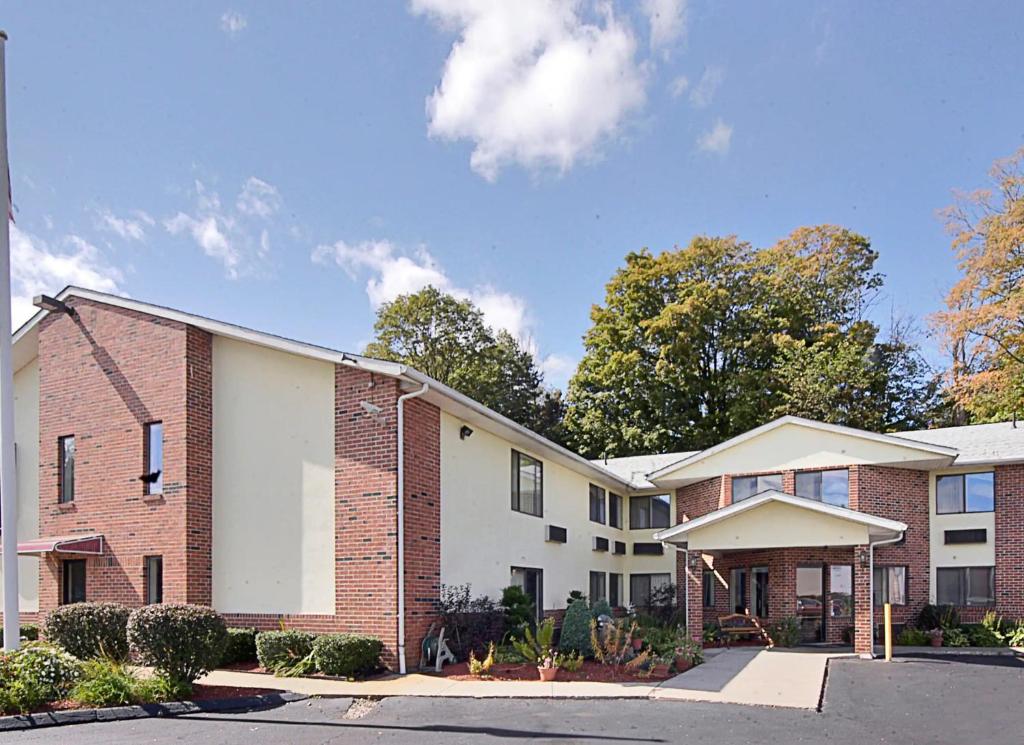 un edificio de ladrillo y blanco con árboles en el fondo en Riverdale Inn, en Springfield