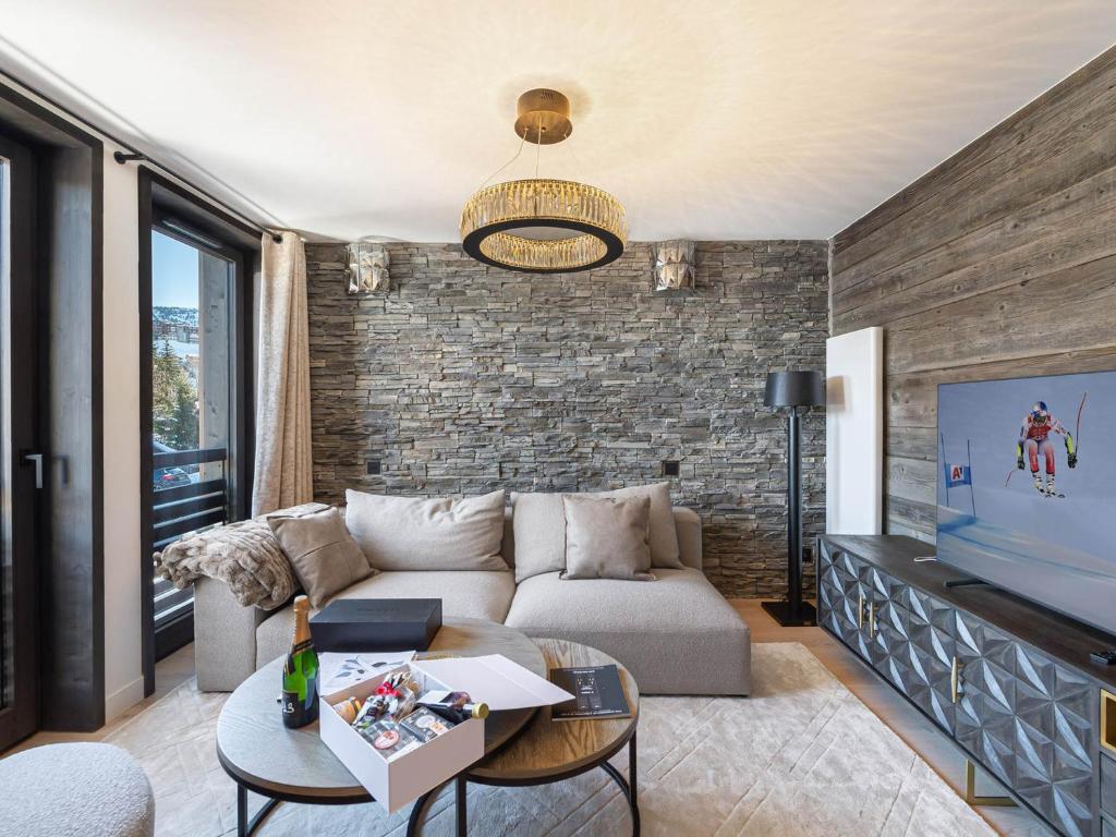 salon z kanapą i telewizorem w obiekcie Chalet de charme à Courchevel, 4 chambres, sauna, cheminée, proche commerces et pistes - FR-1-562-59 w Courchevel