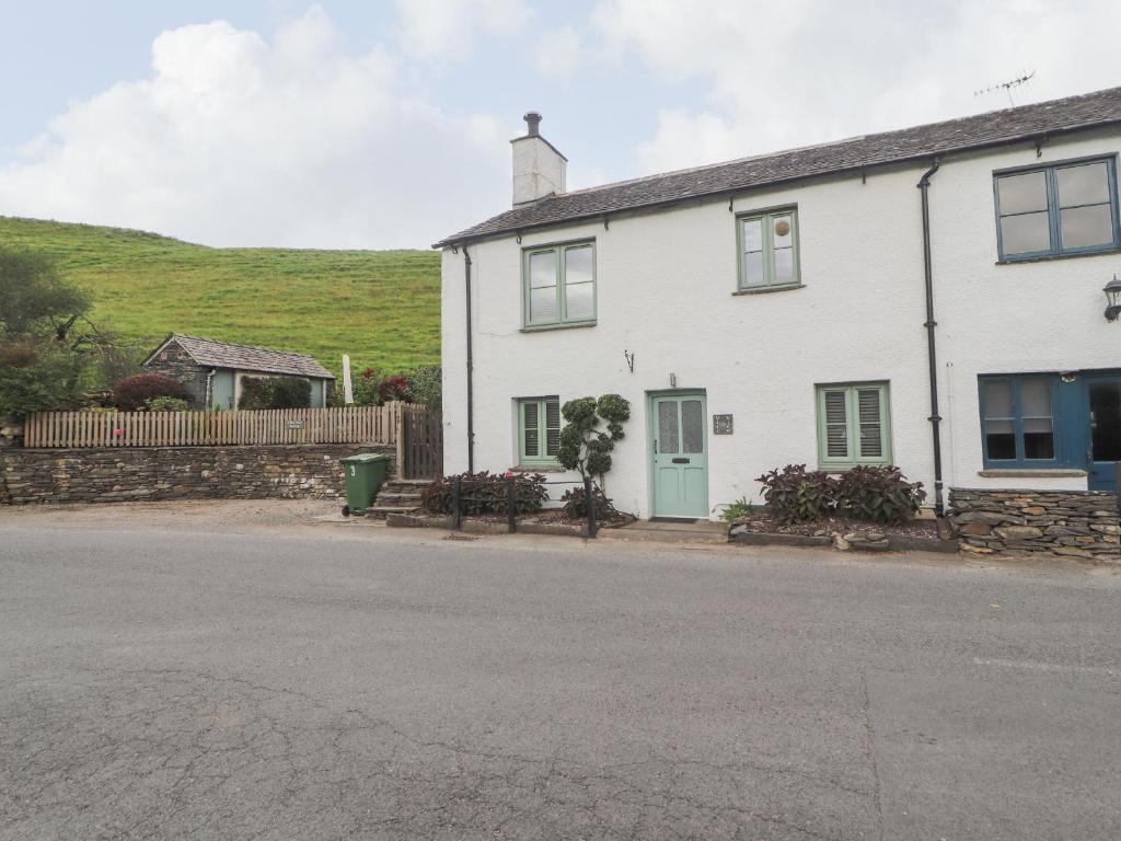 ein weißes Haus mit grüner Tür auf einer Straße in der Unterkunft 3 Vale View in Hawkshead