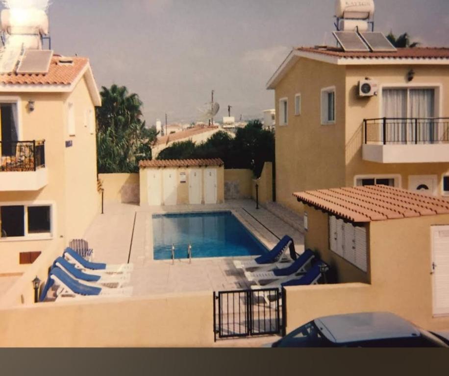 een zwembad aan de zijkant van een huis bij Apartment in residential complex with pool in Klorakas
