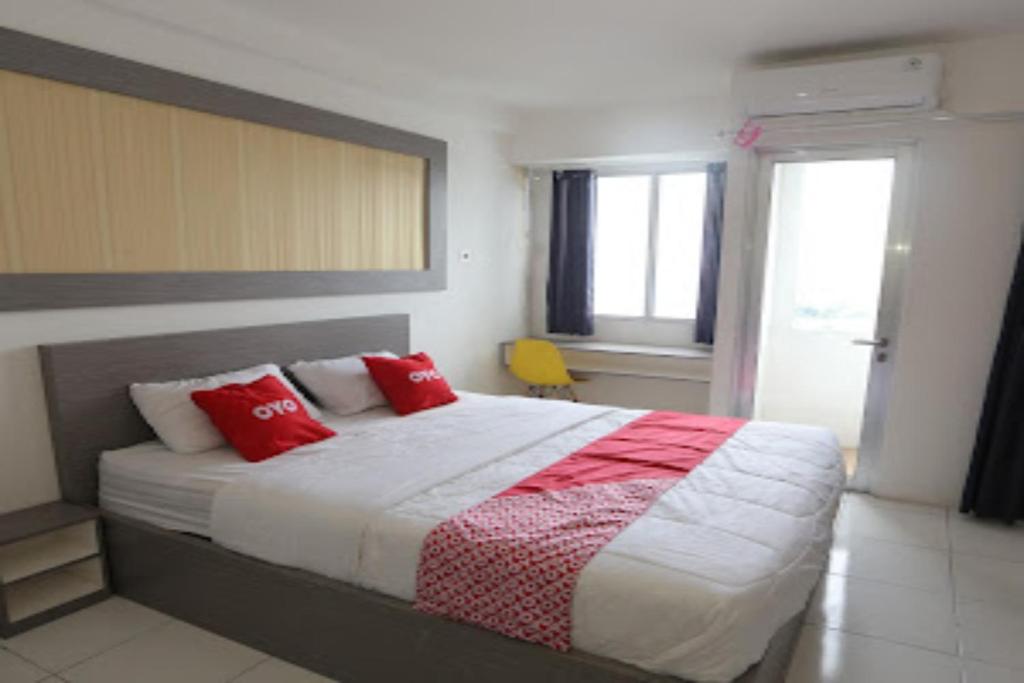 sypialnia z dużym łóżkiem z czerwonymi poduszkami w obiekcie OYO Life 92859 Biant House w mieście Bekasi