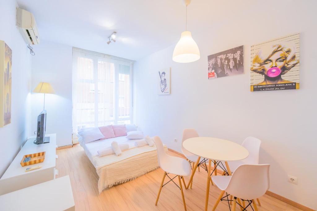 sala de estar con sofá, mesa y sillas en For You Rentals Bonito y cómodo estudio cerca al Barrio Tetuán M (ARA1) en Madrid