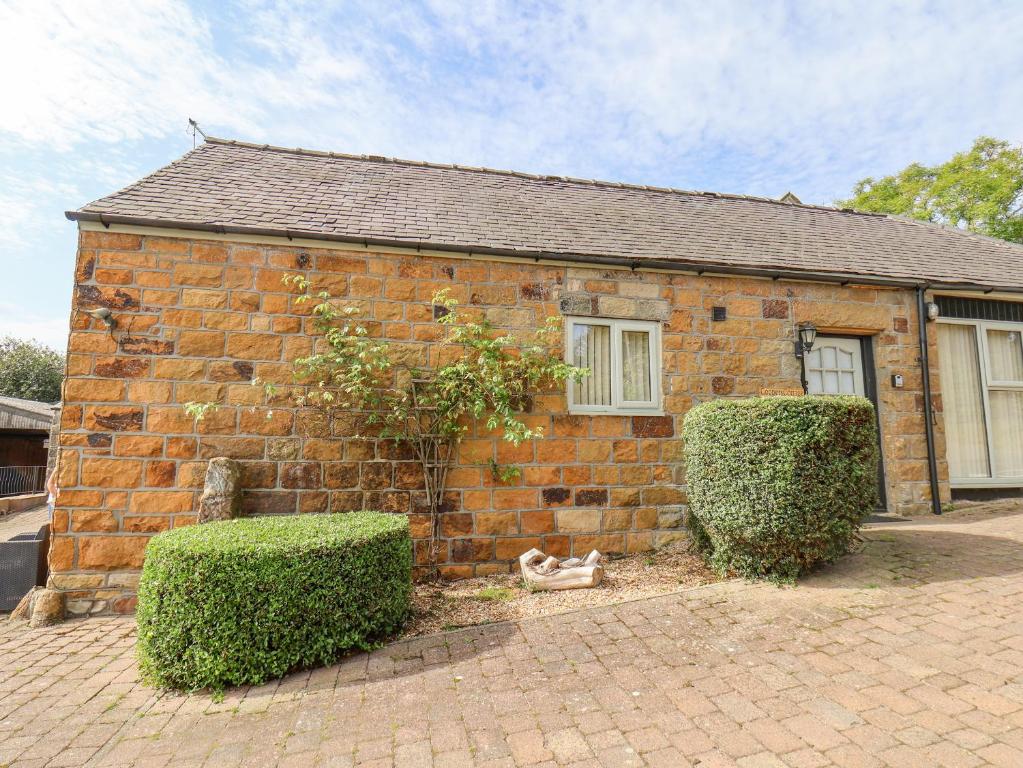 a brick house with a cat sitting outside of it at Coopers Cottage in Whitby