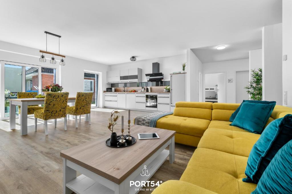 ein Wohnzimmer mit einem gelben Sofa und einem Tisch in der Unterkunft Ferienwohnung Ostseeinsel Fehmarn in Fehmarn