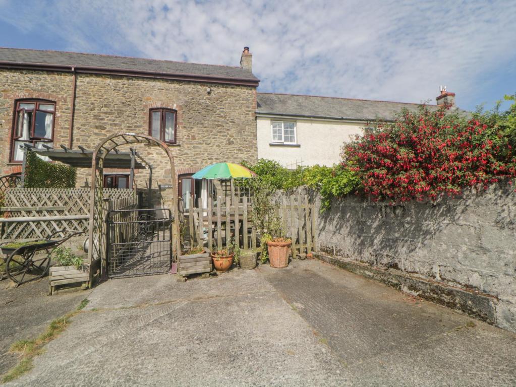 una casa con una valla y una sombrilla en The Orchard en Okehampton