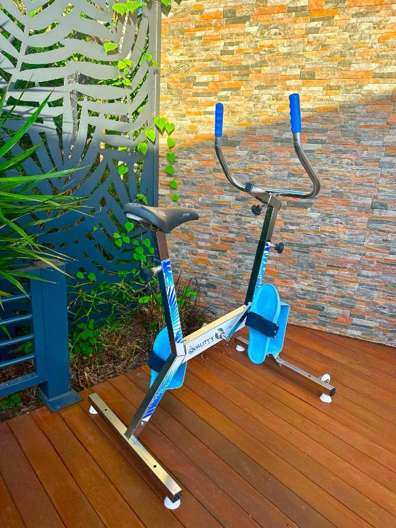 a exercise bike is sitting on a wooden deck at La Parenthèse chez Seb et Gwen in Le Tampon