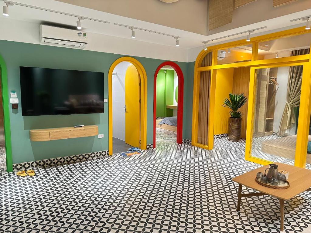a living room with a tv and yellow and green walls at A4 Home - Ha Long city Central in Ha Long