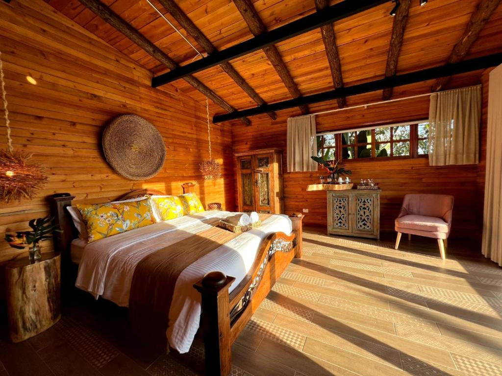 um quarto com uma cama num chalé de madeira em La Perla Finca Hotel em Gigante