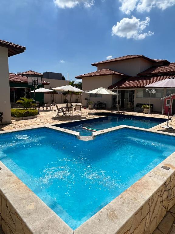 a large blue swimming pool in front of a house at Chácara Familiar Boituva in Boituva