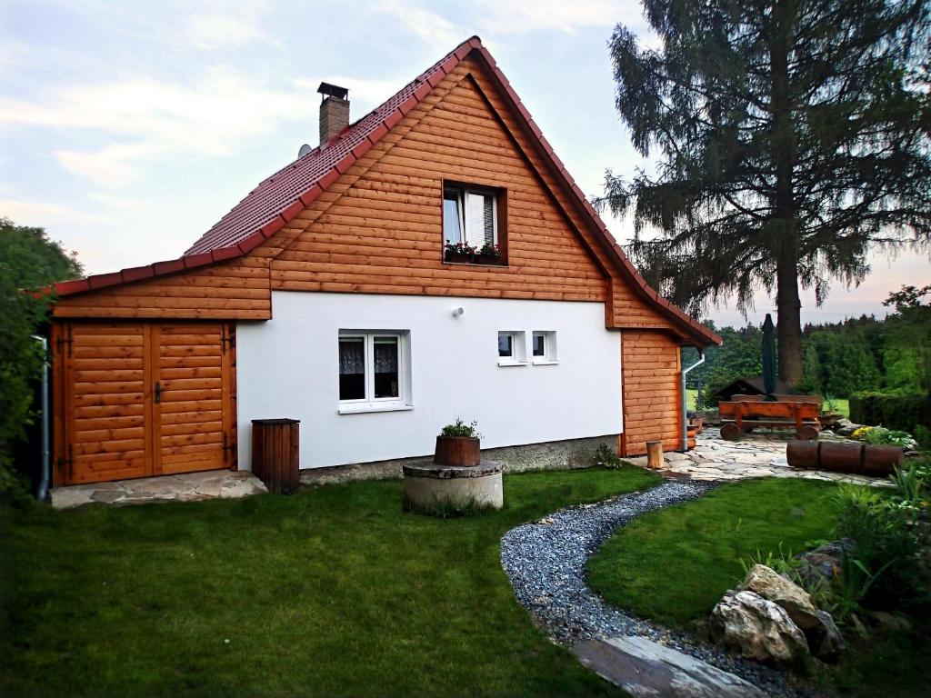 een klein wit huis met een houten dak bij Chata Venda in Lipno nad Vltavou