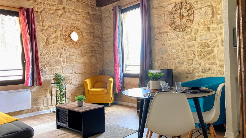 - un salon avec une table et des chaises jaunes dans l'établissement Logement 3 Apparts Centre historique St Gilles MaisoncarreeConciergerie, à Saint-Gilles