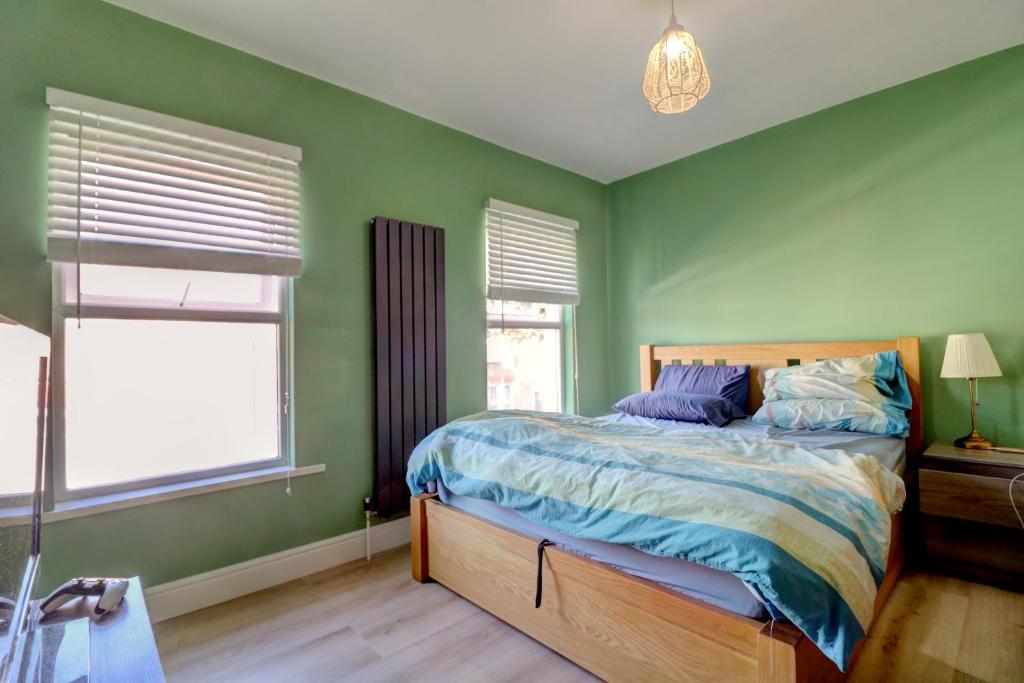 Davis Street في لندن: غرفة نوم خضراء بسرير ونوافذ