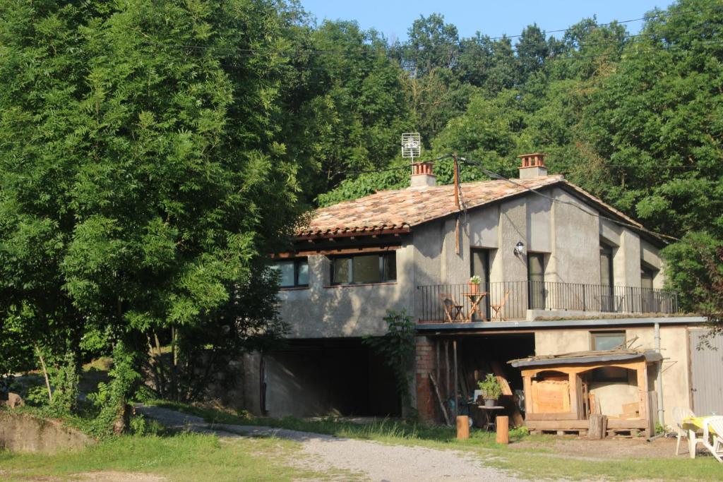 een oud huis met een garage in het bos bij Casa de camp Les Tretes in Les Preses