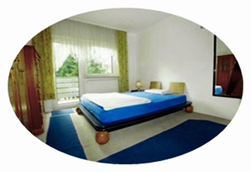 um quarto com uma cama azul e uma janela em Fewowellnesspalast em Bad Nauheim