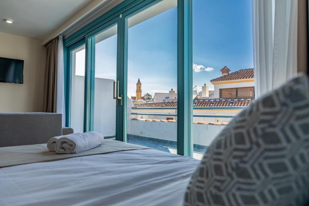a bedroom with a bed and a large window with a view at Hotel Boutique La Brisa del Mar in Estepona