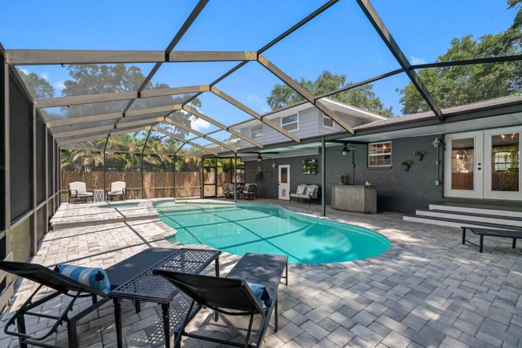a patio with a pool with a table and chairs at Clearwater 2 story pool home mins from the beach in Clearwater