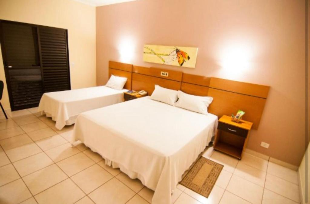 a hotel room with two beds and a television at Real Palace Hotel in Três Lagoas