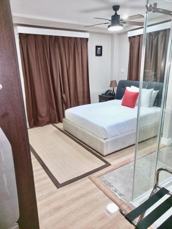 a bedroom with a bed and a glass wall at Myah's Hotel in Brighton Village