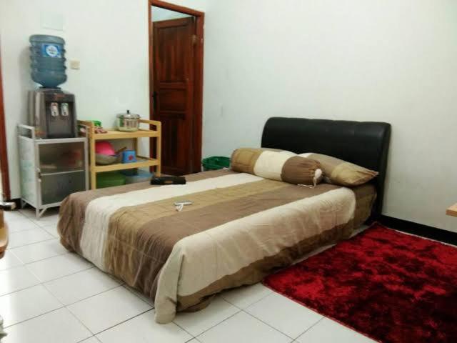 a large bed in a room with a red rug at Dulcon278 in Sukarami