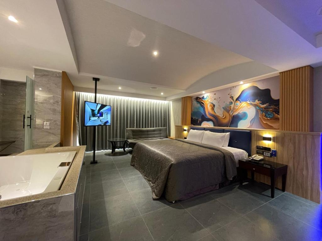 仁德區的住宿－國妃鷹堡汽車旅館仁德館，一间卧室配有一张床、一个浴缸和一台电视。