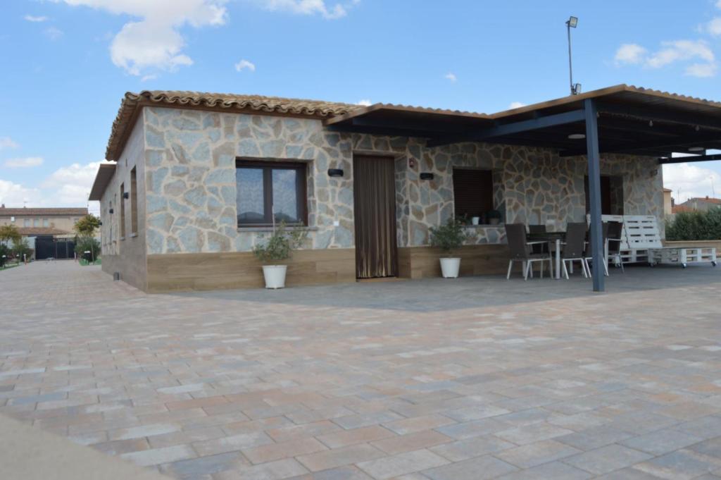 una casa de piedra con un patio frente a ella en Casa Rural Finca Bella, en San Clemente