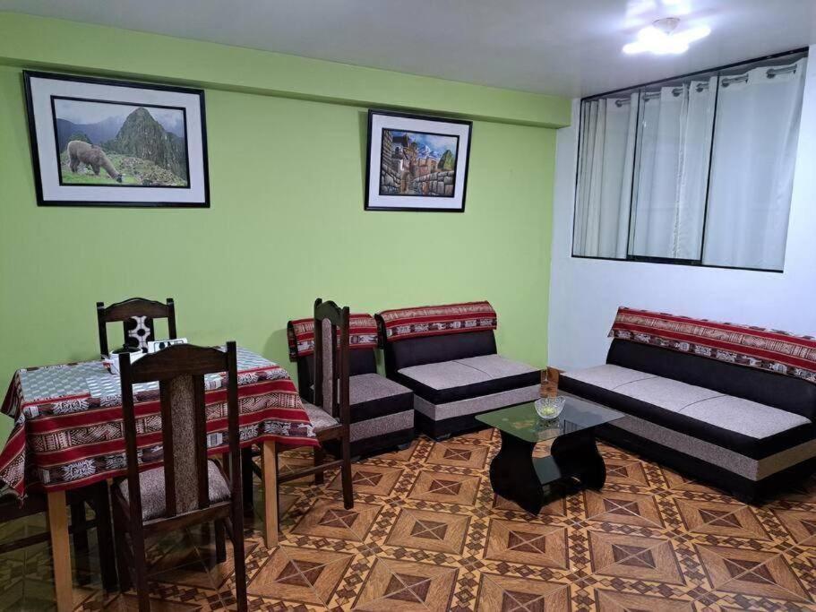ein Wohnzimmer mit Stühlen, einem Tisch und einem Sofa in der Unterkunft Julio Reyna Apartamento in Cusco