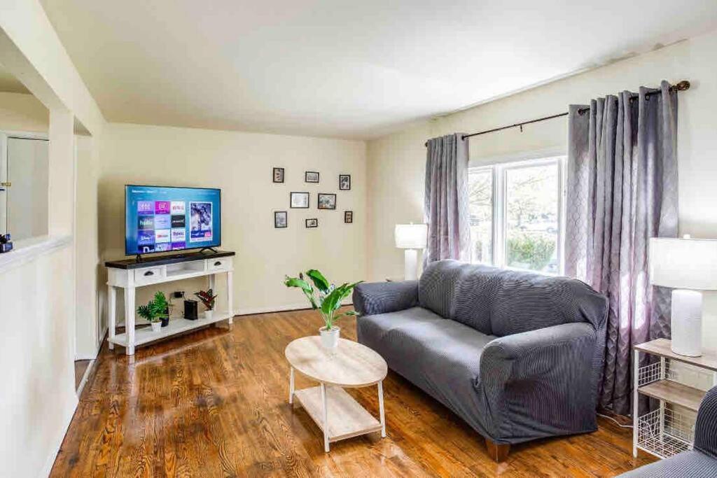 een woonkamer met een bank en een tv bij Peaceful Suburb Home mins from RIT/Airpt/DWTN in Henrietta