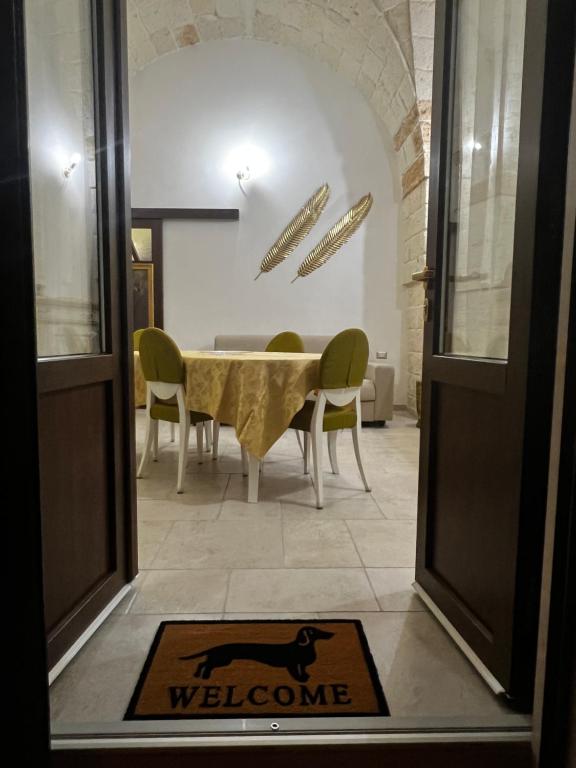 una alfombra de bienvenida frente a una mesa y sillas en Il Bassotto en Brindisi