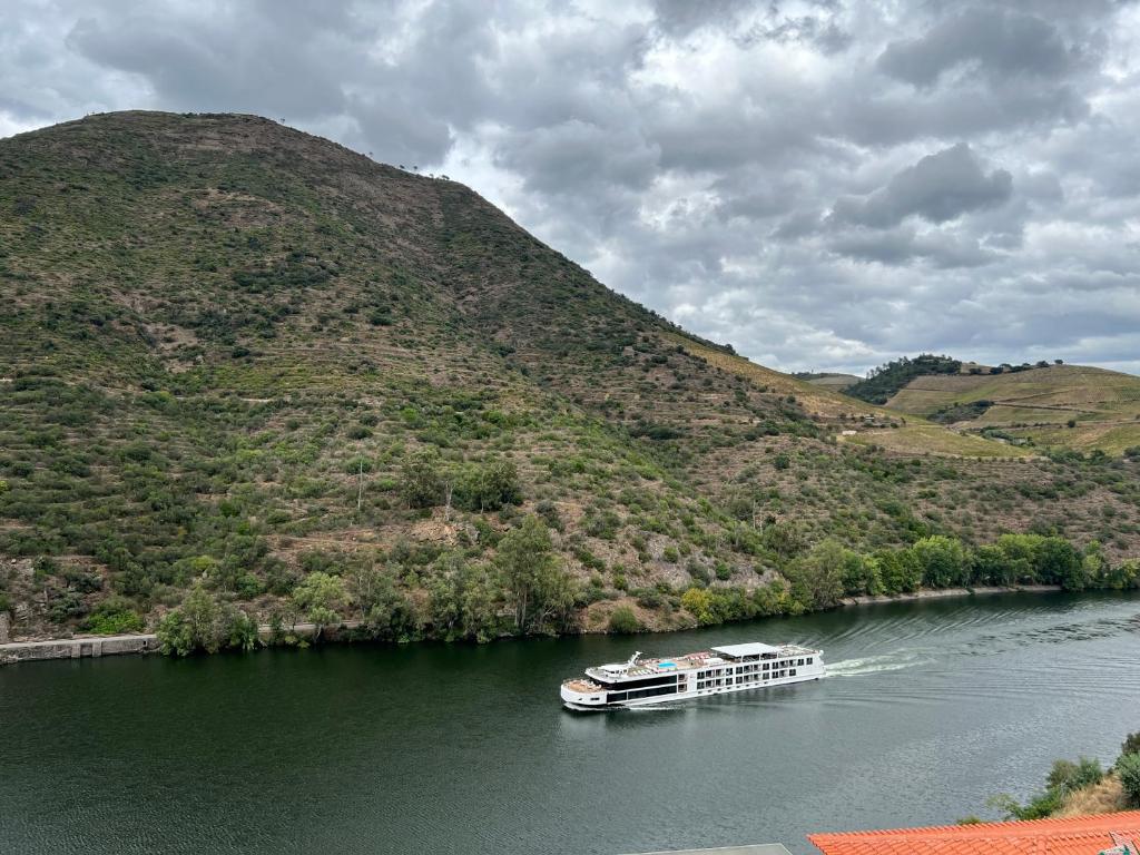 una barca su un fiume con una montagna di Vilas Quinta da Pedra Caldeira ad Armamar