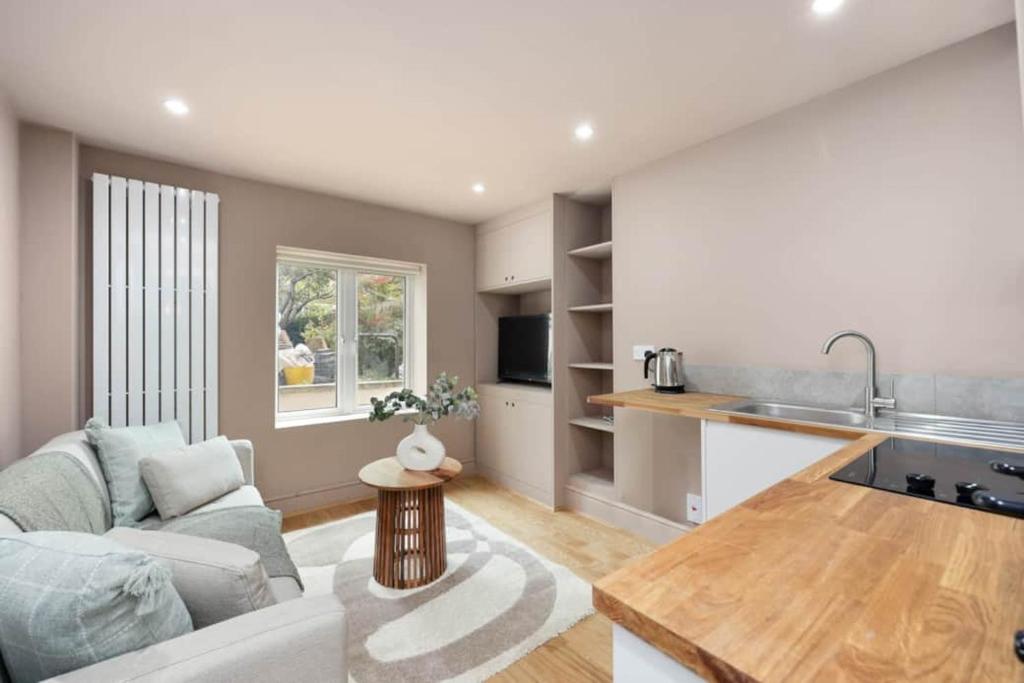 a kitchen and living room with a couch and a table at Camden Garden Apartments in London