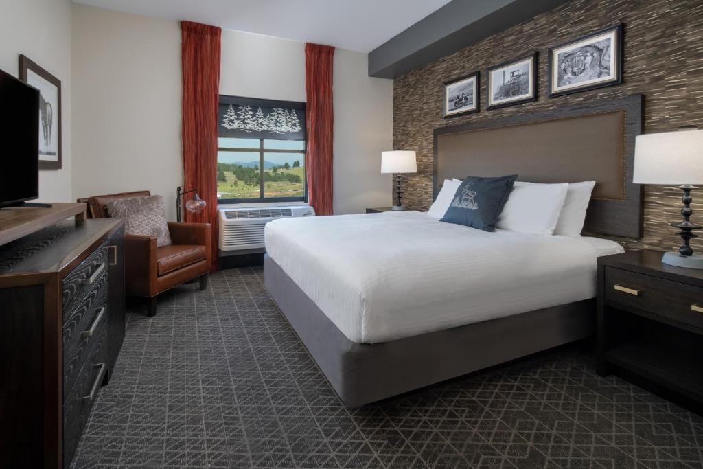 a hotel room with a large bed and a television at Golden Nugget & Gold King Mountain Inn in Cripple Creek