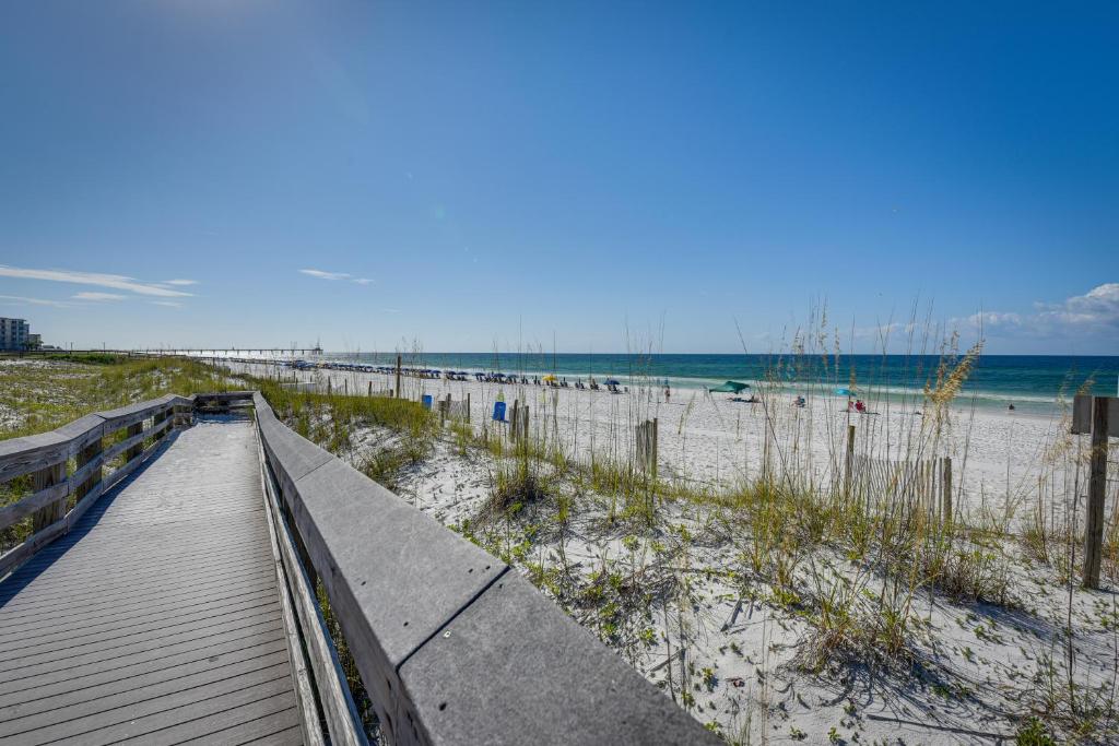 a boardwalk leading to a beach with the ocean at Okaloosa Island Condo Near Boardwalk and Beach! in Fort Walton Beach