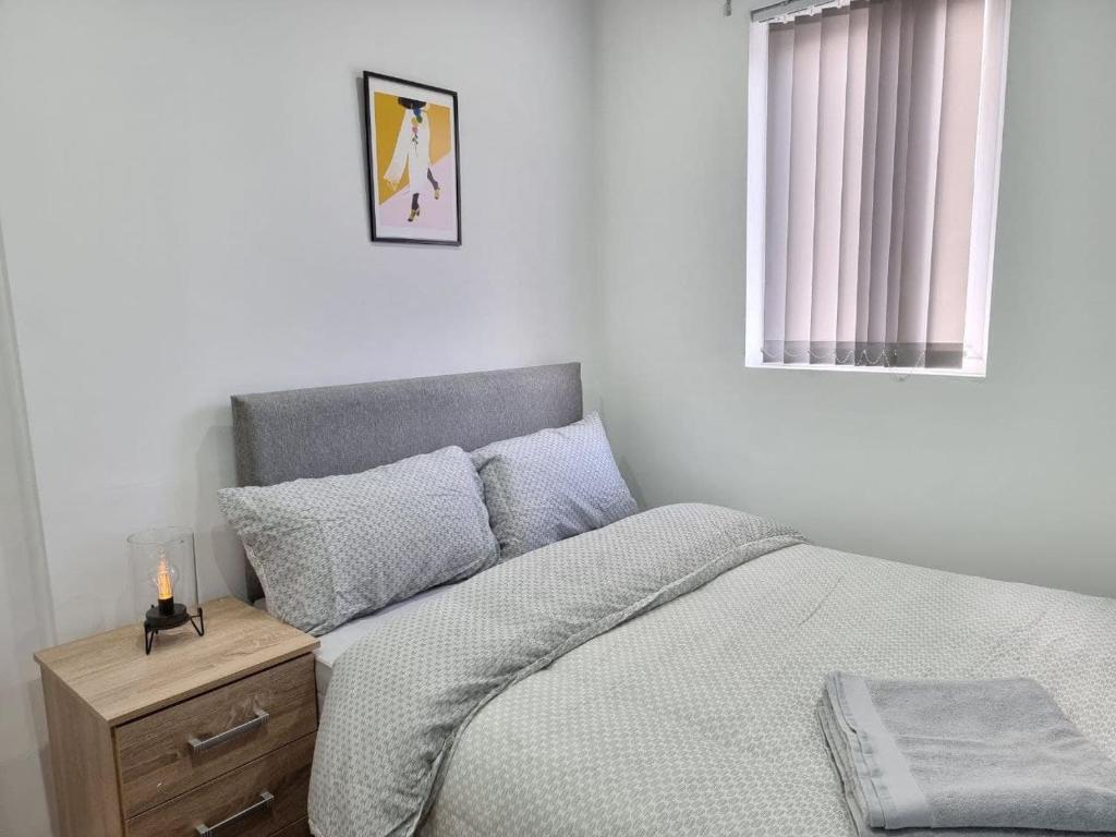 a white bedroom with a bed and a window at Alluring and hospitable chamber in Liverpool
