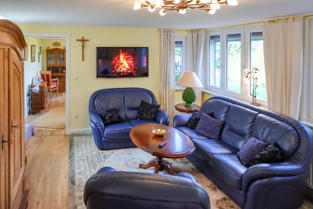 a living room with blue leather couches and a table at Ferienwohnung mit ländlichem Charme in Rodgau
