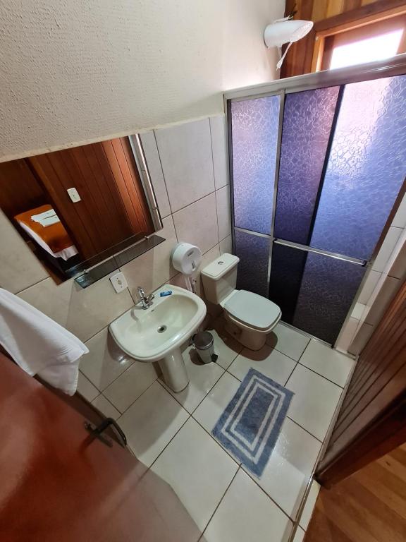 a bathroom with a toilet and a sink at POUSADA POR DO SOL in Olímpia