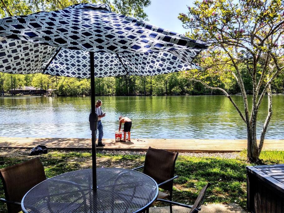 una mesa con sombrilla frente a un lago en Spacious Lakeside Country Getaway! en Hot Springs